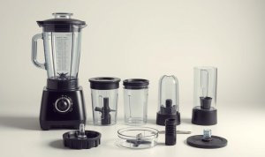Foto blender lengkap dengan berbagai komponennya, termasuk wadah utama, beberapa jar tambahan, pisau blender, tutup, dan aksesori lainnya yang ditata rapi di permukaan datar dengan latar belakang netral.