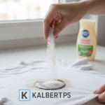 Tangan menaburkan tepung maizena atau baking soda pada noda minyak di baju putih. Ilustrasi protokol menghilangkan noda minyak KALBERTPS.